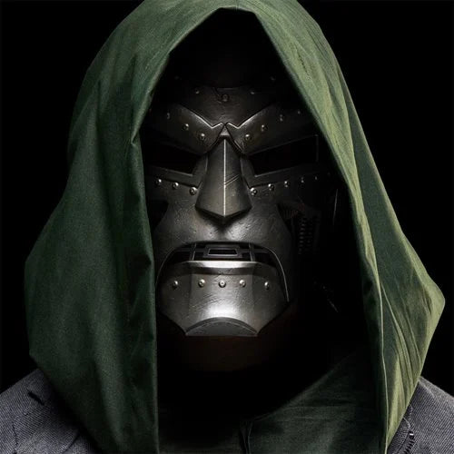 Close-up of a person wearing the Doctor Doom helmet under a hood in a shadowy dramatic setting.