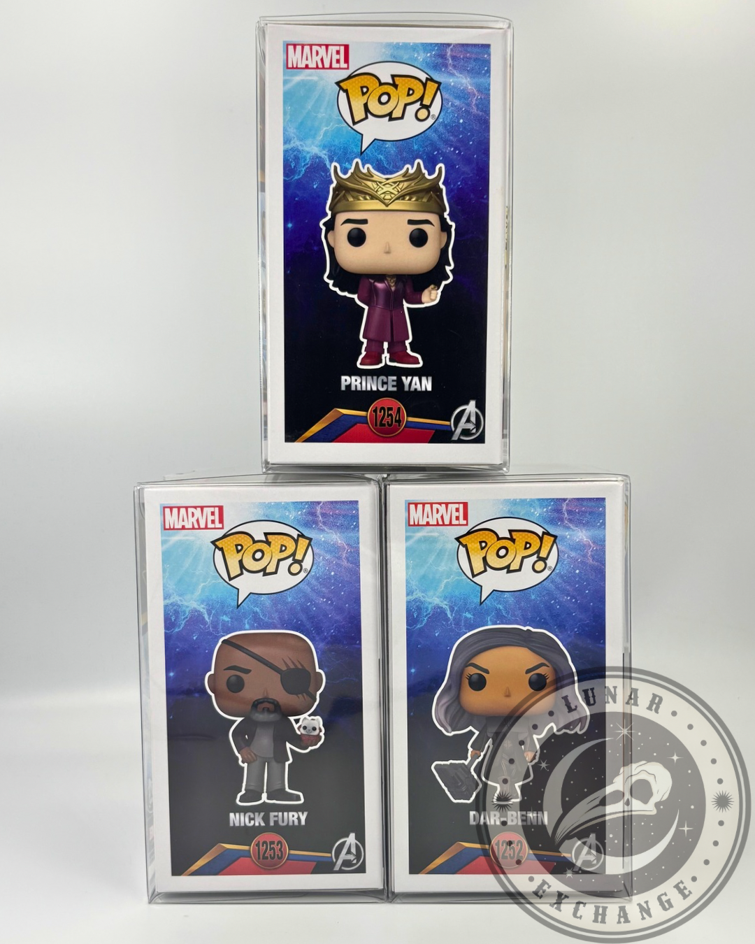 Front art display of The Marvels Funko Pop! boxes with cosmic blue backgrounds: Prince Yan, Nick Fury, and Dar-Benn stacked in formation with clear protectors.