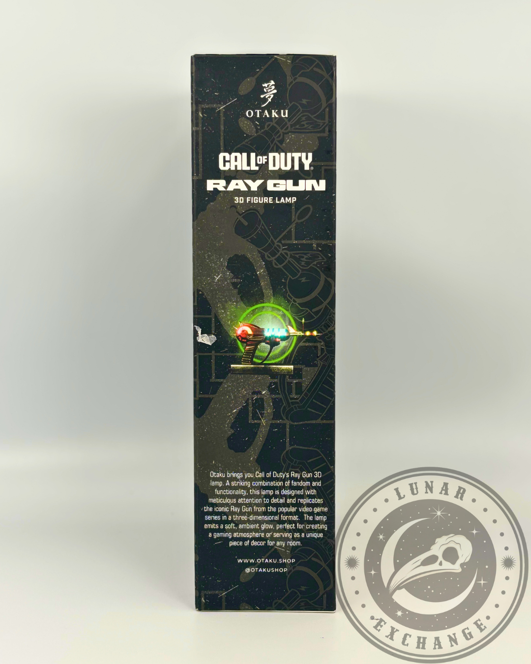 Side of the box featuring a detailed product description by Otaku, highlighting the Ray Gun's glow, nostalgic appeal, and decorative use.