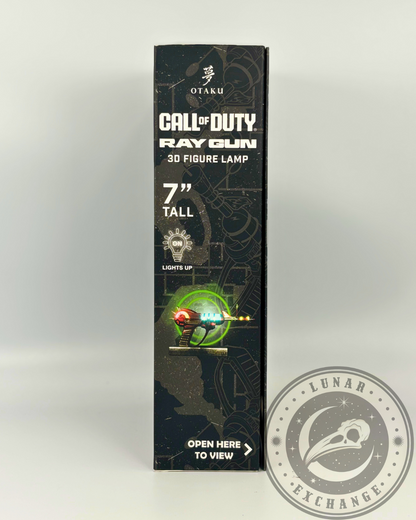 Side panel of the Call of Duty Ray Gun box showing product dimensions, “Lights Up” feature icon, and interactive "Open Here to View" label.