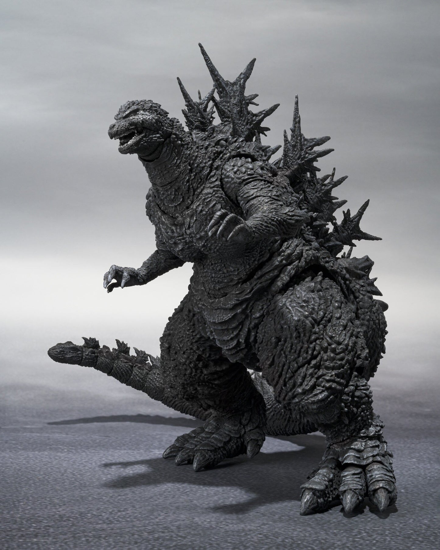 Side profile of the S.H.MonsterArts Godzilla Minus One figure showing detailed right-side sculpt and aggressive stance.