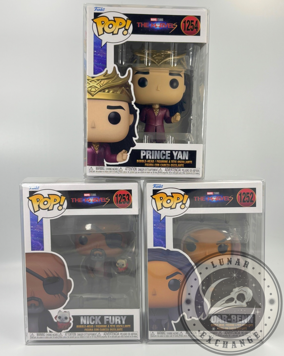 Front view of boxed Funko Pop! figures from The Marvels set: Prince Yan, Nick Fury with Goose, and Dar-Benn, in protective cases with Lunar Exchange logo watermark.